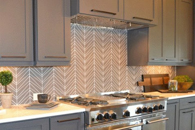 Elegant kitchen photo in New Orleans with recessed-panel cabinets, gray cabinets, quartz countertops, ceramic backsplash and stainless steel appliances