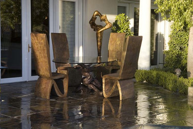 Patio - large contemporary backyard stone patio idea in Las Vegas with a roof extension