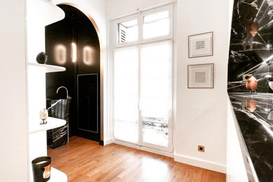 Cette photo montre un petit dressing room chic neutre avec un placard à porte affleurante, des portes de placard blanches, parquet clair et un sol beige.
