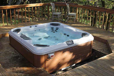 Photo of a large classic back rectangular natural hot tub in San Francisco with decking.
