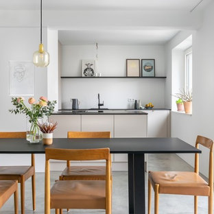 Moderne Wohnküche mit weißer Wandfarbe und grauem Boden in München