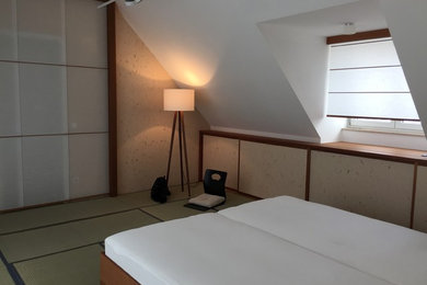 Großes Asiatisches Hauptschlafzimmer mit weißer Wandfarbe, hellem Holzboden und braunem Boden in München