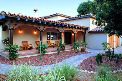 Large tuscan white two-story stucco house exterior photo in Tampa with a hip roof and a tile roof