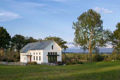 Inspiration for a cottage white two-story house exterior remodel in Burlington with a metal roof