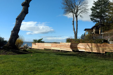 Inspiration for a huge coastal privacy and full sun backyard wood fence and concrete paver landscaping in Vancouver for summer.