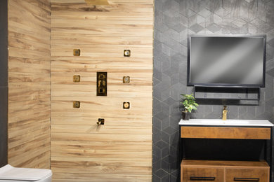 Inspiration for a mid-sized modern 3/4 brown tile and ceramic tile porcelain tile, gray floor and single-sink bathroom remodel in Delhi with open cabinets, light wood cabinets, a wall-mount toilet, gray walls, an integrated sink, white countertops and a freestanding vanity