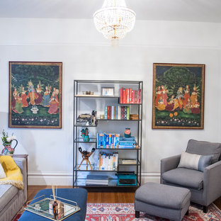 Esempio di un piccolo soggiorno eclettico chiuso con pareti bianche, pavimento in legno massello medio, parete attrezzata e pavimento marrone