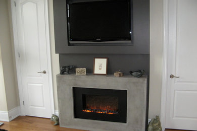 Family room - mid-sized modern enclosed light wood floor family room idea in Toronto with gray walls, a ribbon fireplace and a wall-mounted tv