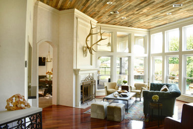 Example of a large eclectic open concept dark wood floor and red floor family room design in Houston with white walls, a standard fireplace, a plaster fireplace and no tv
