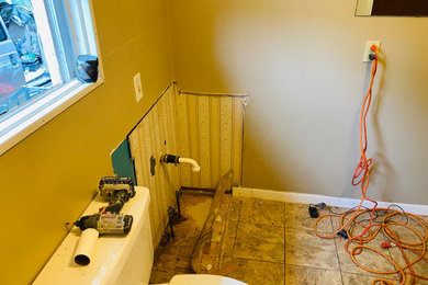 Example of a small master white tile and ceramic tile vinyl floor, brown floor and single-sink doorless shower design in Dallas with white cabinets, solid surface countertops, white countertops, a niche and a freestanding vanity