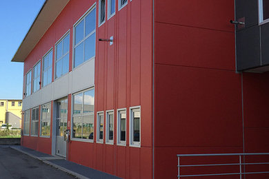 Ispirazione per la facciata di una casa grande rossa industriale a due piani con rivestimento in cemento, tetto piano e copertura mista