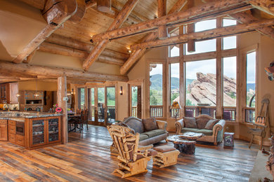 Large mountain style open concept dark wood floor and brown floor living room photo in Other with brown walls, a standard fireplace, a stone fireplace and a wall-mounted tv