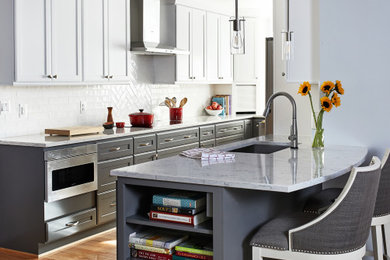 Mid-sized transitional medium tone wood floor eat-in kitchen photo in DC Metro with gray cabinets, white backsplash, subway tile backsplash, stainless steel appliances and a peninsula