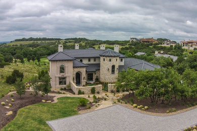 This is an example of a mediterranean front yard driveway in Austin.