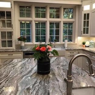 Idées déco pour une grande arrière-cuisine classique en L avec un évier de ferme, un placard avec porte à panneau encastré, des portes de placard blanches, un plan de travail en granite, une crédence blanche, une crédence en carreau de porcelaine, un électroménager en acier inoxydable, un sol en bois brun, un îlot central et un plan de travail bleu.