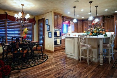 This is an example of a traditional kitchen in Denver with shaker cabinets, distressed cabinets, granite benchtops, stainless steel appliances and dark hardwood floors.