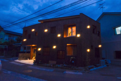 Ejemplo de fachada de casa marrón y gris moderna de tamaño medio de dos plantas con revestimiento de madera, tejado de un solo tendido, tejado de metal y panel y listón