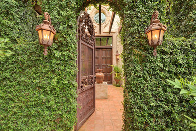 Example of a tuscan entryway design in Austin with a dark wood front door