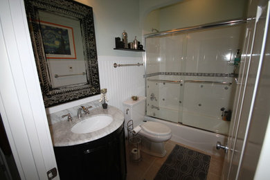 Mid-sized elegant white tile and ceramic tile porcelain tile bathroom photo in Grand Rapids with a one-piece toilet, white walls, an undermount sink and marble countertops