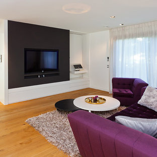 Example of a mid-sized trendy open concept painted wood floor home theater design in Cologne with white walls and a media wall