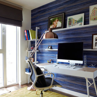 Photo of a small modern study in London with blue walls, dark hardwood flooring, no fireplace and a freestanding desk.