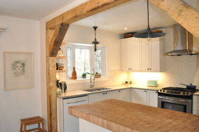 Country ceramic tile and black floor eat-in kitchen photo in Ottawa with a drop-in sink, shaker cabinets, white cabinets, white backsplash, an island and gray countertops