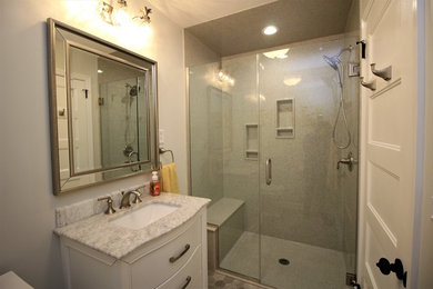 Alcove shower - mid-sized transitional master gray floor alcove shower idea in Other with furniture-like cabinets, white cabinets, a two-piece toilet, gray walls, an undermount sink, marble countertops and a hinged shower door