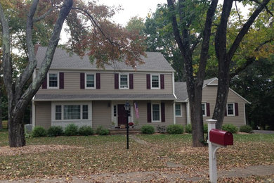 Example of a large classic brown three-story concrete fiberboard gable roof design in New York