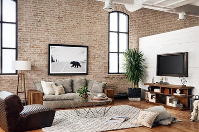 Mid-sized industrial enclosed living room in Ottawa with brown walls, medium hardwood floors, no fireplace, a wall-mounted tv and brown floor.