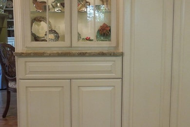 Example of a large classic galley medium tone wood floor eat-in kitchen design in Other with an undermount sink, raised-panel cabinets, white cabinets, granite countertops, beige backsplash, stainless steel appliances and an island