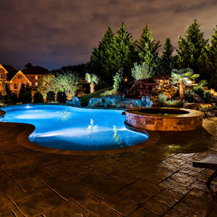 Großer Klassischer Schwimmteich hinter dem Haus in individueller Form mit Wasserspiel und Stempelbeton in Atlanta