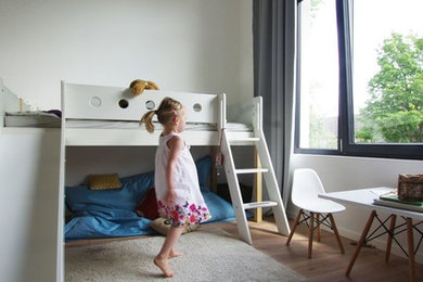 Design ideas for a mid-sized scandinavian kids' playroom for kids 4-10 years old and girls in Dortmund with white walls and carpet.