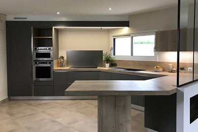 Cette image montre une grande cuisine ouverte minimaliste en L avec un évier 1 bac, un placard à porte affleurante, un plan de travail en stratifié, une crédence en bois et un électroménager en acier inoxydable.