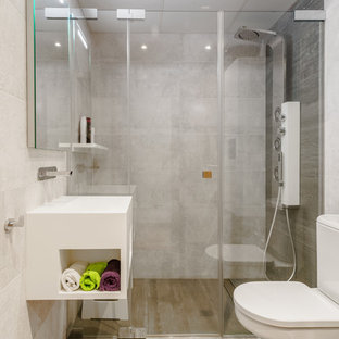 Imagen de cuarto de baño con ducha, actual, con puertas de armario blancas, ducha empotrada, sanitario de dos piezas, baldosas y/o azulejos grises, paredes beige, lavabo suspendido, suelo beige y ducha con puerta con bisagras