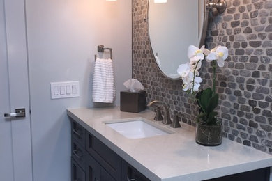 Inspiration for a mid-sized transitional gray tile and pebble tile pebble tile floor bathroom remodel in Phoenix with an undermount sink, shaker cabinets, dark wood cabinets, quartz countertops and multicolored walls