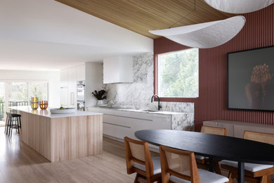 Exemple d'une salle à manger ouverte sur la cuisine rétro en bois avec sol en stratifié.