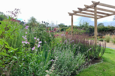Inspiration pour un grand jardin rustique l'été avec une exposition ensoleillée, une pente, une colline ou un talus, du gravier et une clôture en pierre.