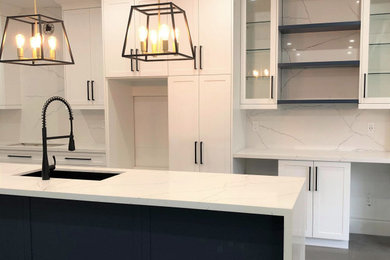 Inspiration for a transitional eat-in kitchen in Toronto with an undermount sink, shaker cabinets, white cabinets, quartzite benchtops, white splashback, engineered quartz splashback, stainless steel appliances, dark hardwood floors, with island, grey floor and white benchtop.