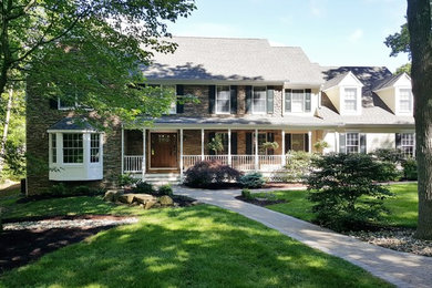 Example of a mid-sized transitional beige two-story mixed siding exterior home design in New York with a shingle roof