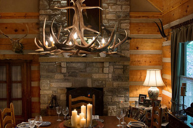 Kitchen/dining room combo - large rustic medium tone wood floor kitchen/dining room combo idea in Nashville with gray walls, a standard fireplace and a stone fireplace