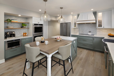 Inspiration for a mid-sized transitional light wood floor kitchen remodel in San Francisco with shaker cabinets, green cabinets, glass countertops, blue backsplash, glass tile backsplash, stainless steel appliances, an island and white countertops