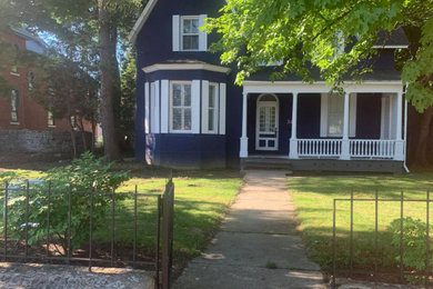 Imagen de fachada de casa azul y gris tradicional extra grande de dos plantas con revestimiento de ladrillo