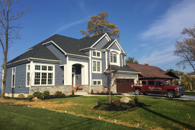 Huge traditional blue two-story mixed siding and board and batten exterior home idea in Cleveland with a gray roof and a shingle roof
