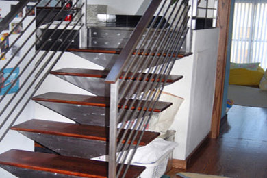 Large minimalist wooden straight staircase photo in Chicago with metal risers