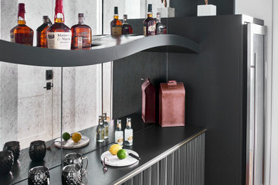 Cette image montre un bar de salon minimaliste avec aucun évier ou lavabo, des étagères flottantes, des portes de placard noires, une crédence miroir, un sol en bois brun et un sol noir.