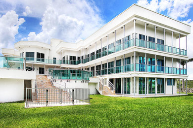 Large modern white three-story exterior home idea in Miami