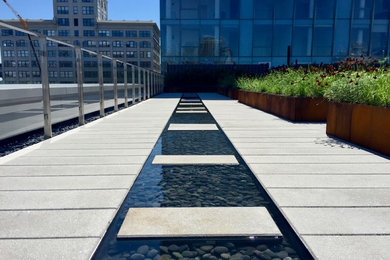 This is an example of a large industrial drought-tolerant and partial sun rooftop concrete paver water fountain landscape in New York.