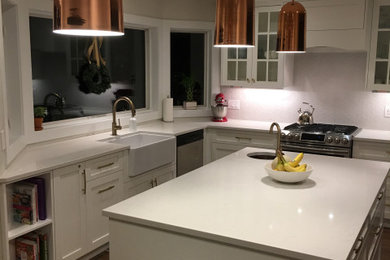 Example of a large transitional l-shaped eat-in kitchen design in Other with a farmhouse sink, shaker cabinets, white cabinets, quartz countertops, stainless steel appliances, an island and white countertops