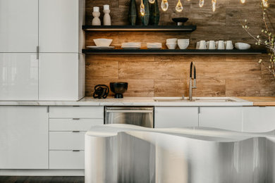 Kitchen - contemporary galley dark wood floor and brown floor kitchen idea in San Francisco with an undermount sink, flat-panel cabinets, white cabinets, stainless steel appliances, an island and white countertops