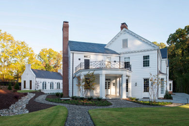 Elegant white two-story wood and clapboard exterior home photo in Raleigh with a shingle roof and a gray roof